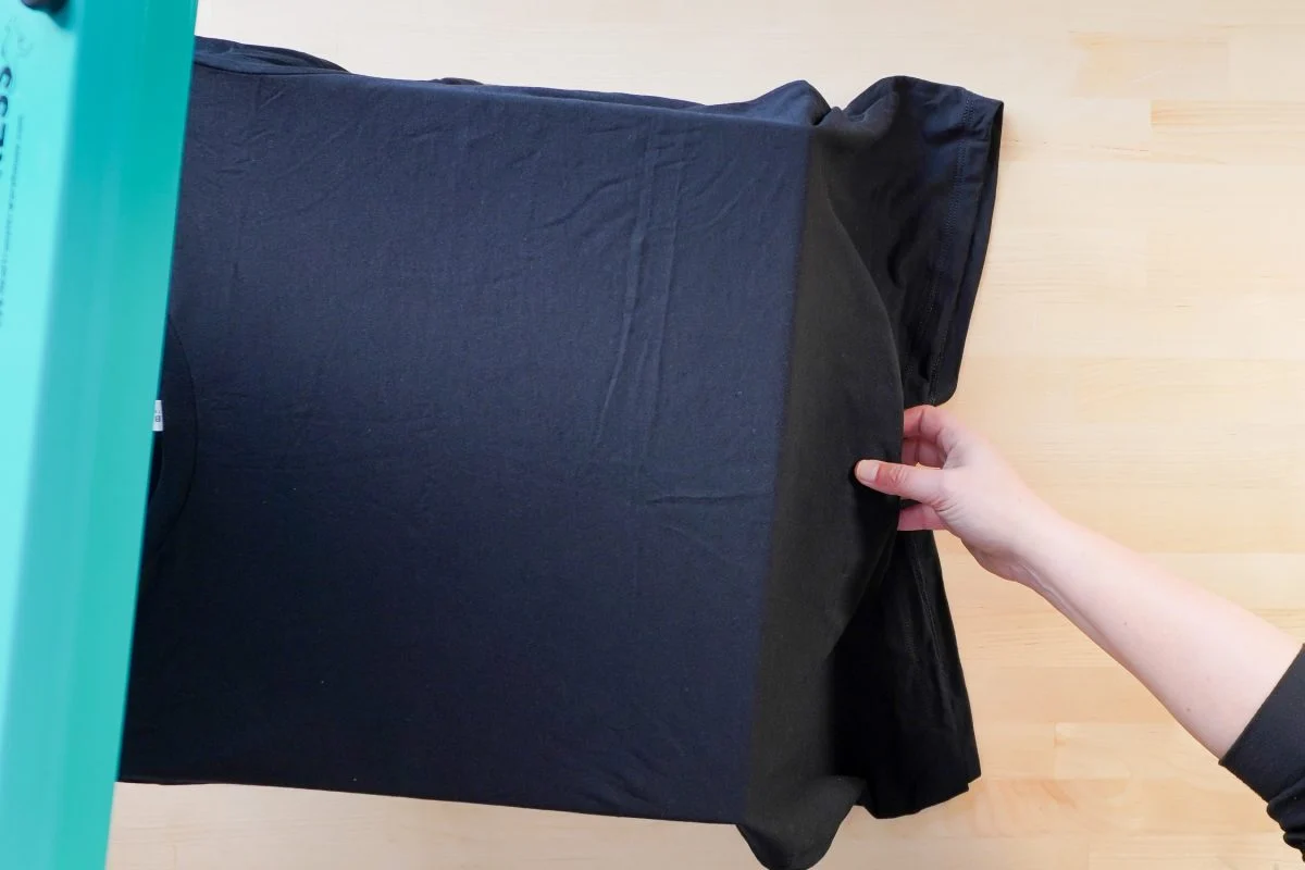 Placing the garment on the heat press before applying a DTF transfer