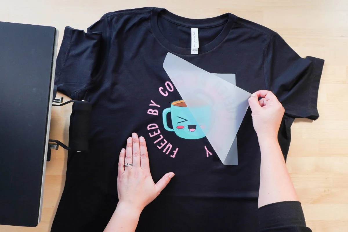 Peeling the film off the garment after heat pressing a DTF transfer