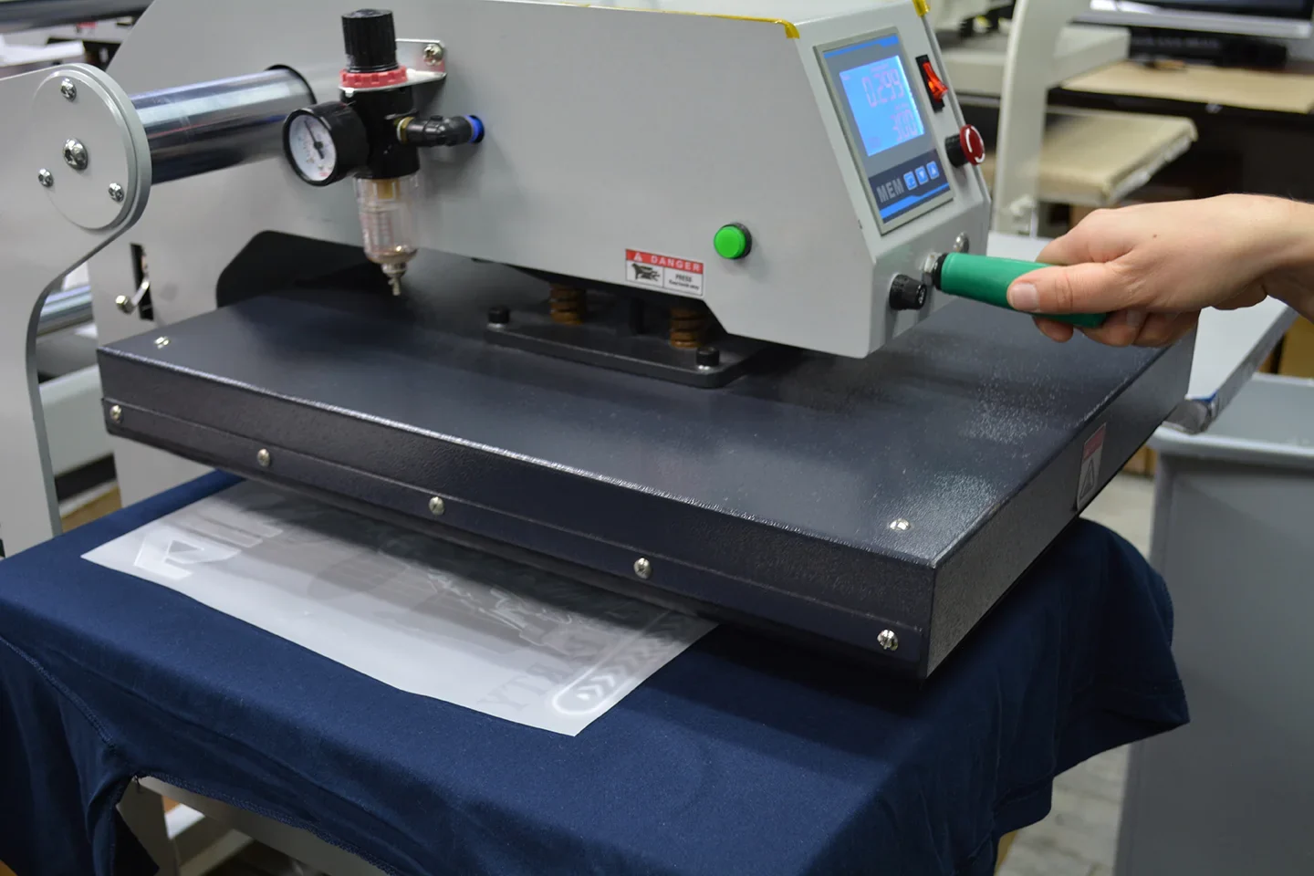 Heat press machine applying a DTF transfer onto a garment
